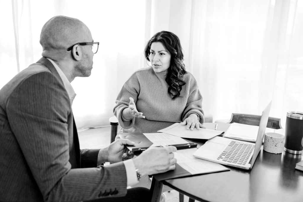 A financial advisor sitting at a table speaking with their client