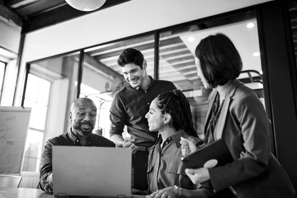 group-of-entrepreneurs-smiling-cheerfully-and-using-laptop-in-boardroom